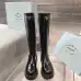 Prada's Sleek Black Knee-High Boots Featuring Glossy Texture and Iconic Logo #B54538